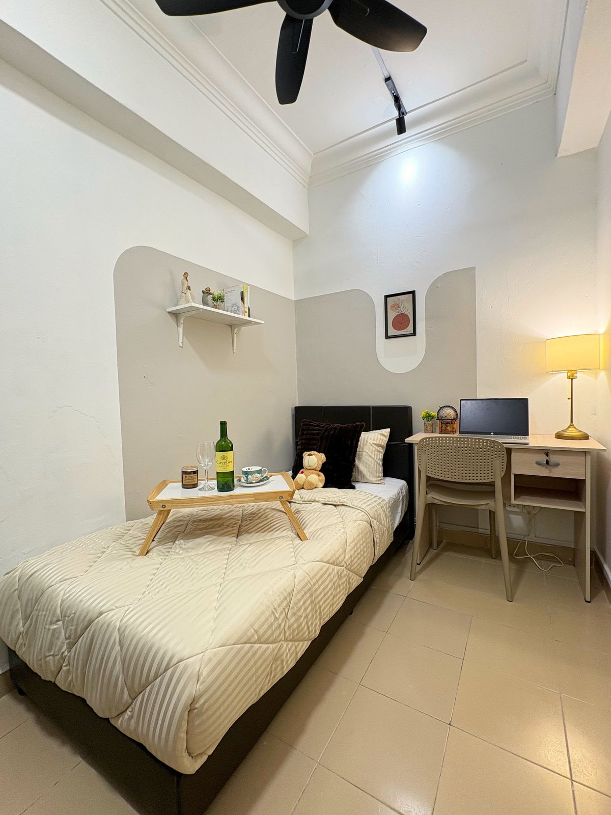 Single bedroom with a black headboard, study desk, and lamp